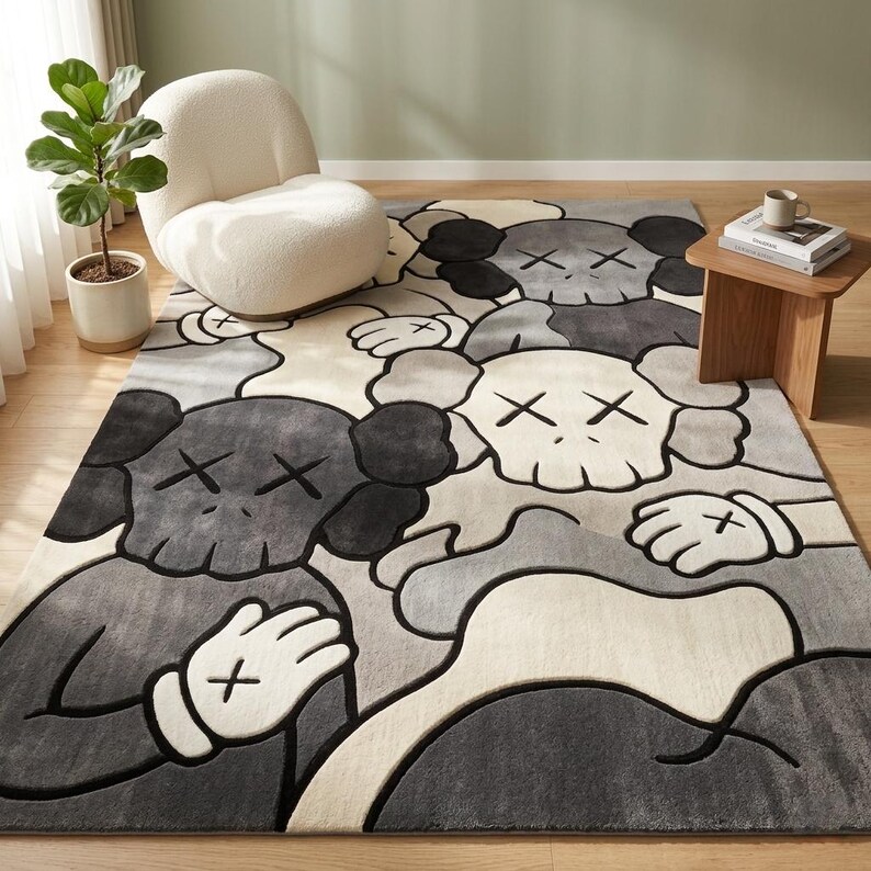 Striking modern rug in a minimalist living room. It features a dense wool texture and an abstract pattern of overlapping Kaws style companion figures with crossed eyes and gloved hands, rendered in rich shades of cream, light grey, dark grey, and black. The plush hand-carved design feels upscale and contemporary on a warm wood floor.