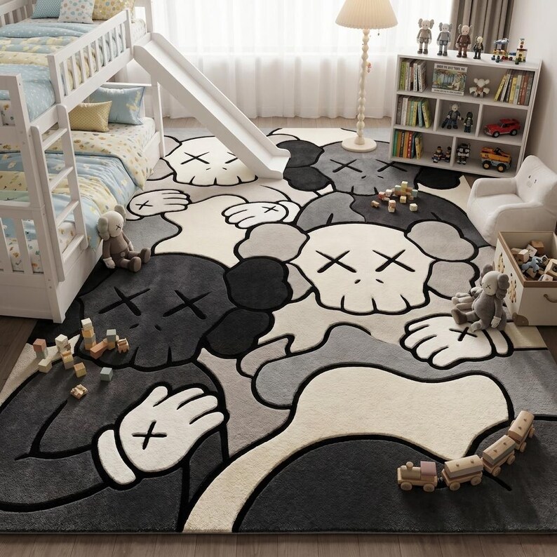 Striking modern rug in a minimalist living room. It features a dense wool texture and an abstract pattern of overlapping Kaws style companion figures with crossed eyes and gloved hands, rendered in rich shades of cream, light grey, dark grey, and black. The plush hand-carved design feels upscale and contemporary on a warm wood floor.