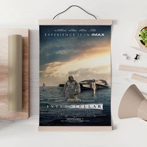 Op de afbeelding: Een filmposter voor "Interstellar" met astronauten in water en een ruimteschip. De poster bevat de titel van de film en de tekst "Experience it in IMAX". De releasedatum is 7 november.
