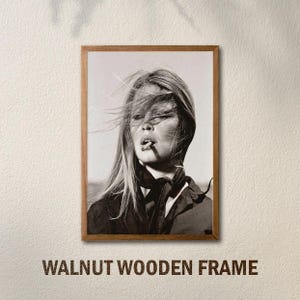 May include: Black and white framed print of a woman with long hair and a cigarette. The image is in a walnut wooden frame. The text "WALNUT WOODEN FRAME" is at the bottom of the image.