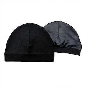 May include: Two black beanies are displayed against a white background. One beanie is shown inside out, revealing a satin lining. The beanies are made of a soft, dark material and have a simple, classic design. The beanies are likely for hair protection.
