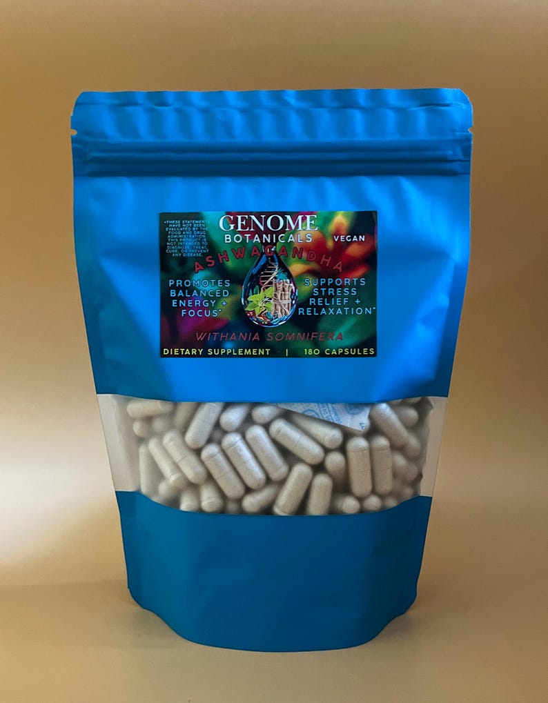 K&ouml;nnte beinhalten: Ein blauer Beutel mit Genome Botanicals Ashwagandha Nahrungserg&auml;nzungsmittel. Der Beutel hat ein klares Fenster mit wei&szlig;en Kapseln. Der Text auf dem Etikett lautet "F&ouml;rdert ausgewogene Energie + Fokus" und "Unterst&uuml;tzt Stressabbau + Entspannung."