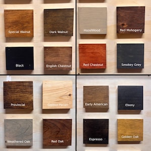 May include: A grid of wooden stain samples in various colors, including Special Walnut, Dark Walnut, Black, and Red Mahogany. Each sample is labeled with its name. The samples are square and mounted on a light-colored surface.