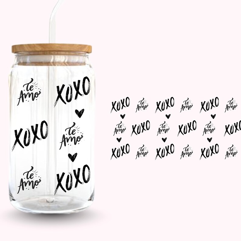 Pu&ograve; includere: Un bicchiere di vetro trasparente con coperchio in legno e cannuccia bianca. Il bicchiere &egrave; decorato con le parole "XOXO" e "Te Amo" in grafia nera, insieme a piccoli cuori neri. Il disegno si ripete su sfondo rosa.