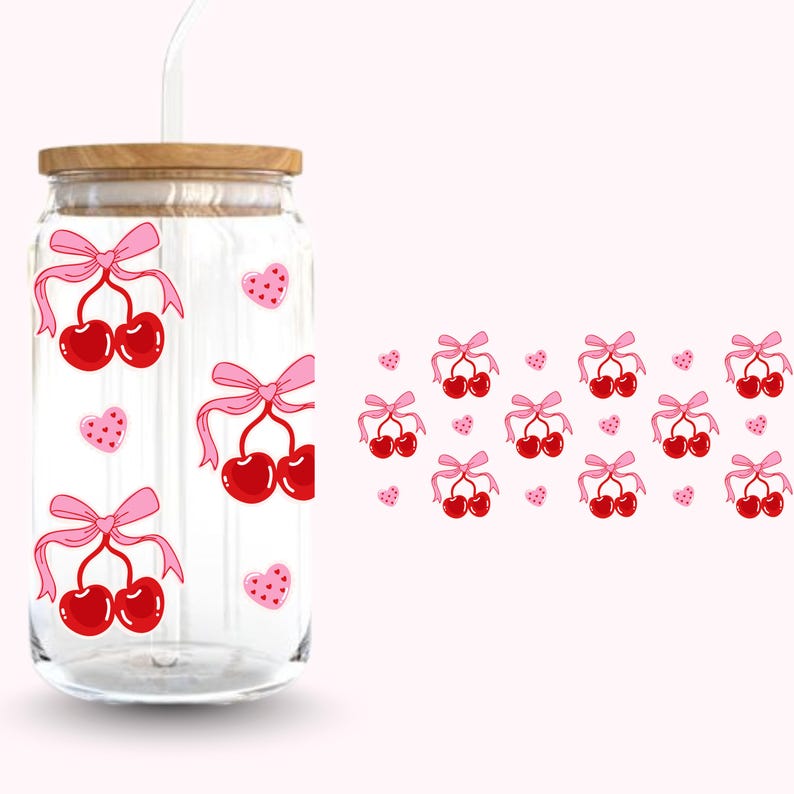 Pu&ograve; includere: Un bicchiere di vetro trasparente con coperchio in legno e cannuccia. Il bicchiere &egrave; decorato con ciliegie rosse legate con fiocchi rosa e piccoli cuori rosa. Lo sfondo &egrave; rosa chiaro.