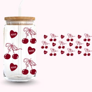 Pu&ograve; includere: Un barattolo di vetro trasparente con coperchio in legno e cannuccia bianca. Il barattolo &egrave; decorato con ciliegie rosso scuro e cuori con la scritta "XOXO". Lo sfondo &egrave; rosa chiaro.