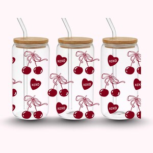 Pu&ograve; includere: Tre bicchieri di vetro trasparente con coperchi in bamb&ugrave; e cannucce trasparenti. Ogni bicchiere presenta un motivo ripetuto di ciliegie rosse e cuori con la scritta "XOXO". Le ciliegie hanno un design a fiocco.