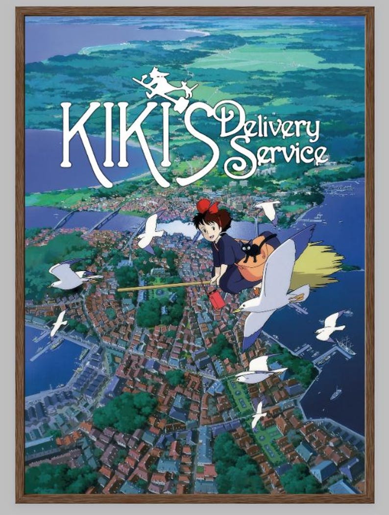K&ouml;nnte beinhalten: Ein gerahmtes Poster des Animationsfilms "Kikis kleiner Lieferservice". Es zeigt eine junge Hexe auf einem Besen &uuml;ber einer K&uuml;stenstadt fliegend. Der Titel ist in Wei&szlig; dargestellt. Die Szene spielt vor blauem Himmel und Meer, mit M&ouml;wen.
