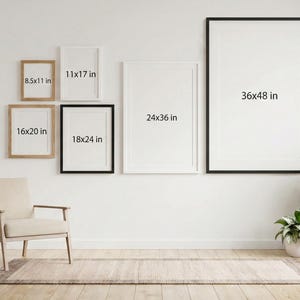K&ouml;nnte beinhalten: Eine Sammlung gerahmter Kunstdrucke in verschiedenen Gr&ouml;&szlig;en, darunter 21,6x28 cm, 28x43 cm, 40,6x51 cm, 45,7x61 cm, 61x91 cm und 91x122 cm. Die Rahmen sind in Schwarz- und Naturholzt&ouml;nen gehalten und an einer wei&szlig;en Wand ausgestellt. Ein beiger Sessel und Pflanzen befinden sich im Vordergrund.