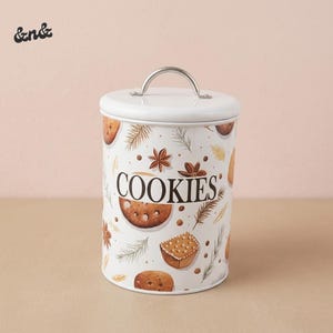 May include: White cookie jar with a silver handle and lid. The jar is decorated with illustrations of cookies, star anise, and sprigs on a white background. The word "COOKIES" is printed on the front.