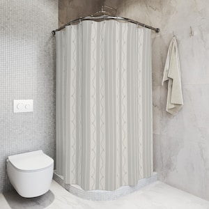 May include: A light gray and white striped shower curtain with a decorative wavy pattern. The curtain hangs from a curved metal rod in a bathroom setting. A white toilet and a towel are also visible.