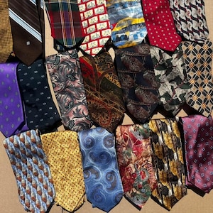 May include: A collection of various neckties with diverse patterns and colors. The ties include stripes, paisley, floral, and geometric designs. Colors range from blue, red, and yellow to purple and brown. The ties are made of various materials.