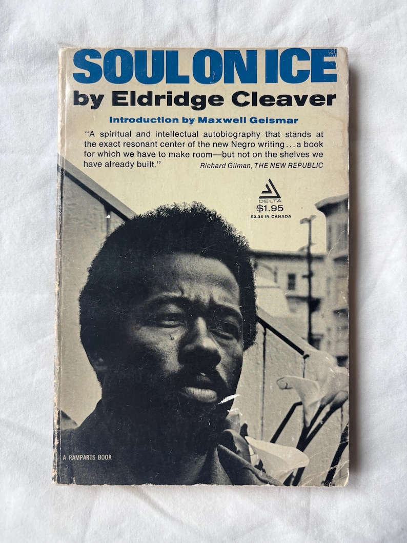 May include: Vintage paperback book titled "Soul on Ice" by Eldridge Cleaver. The cover features a black and white portrait of a man with a beard. The title is in blue, and the author's name is in white. The book is a Delta publication.