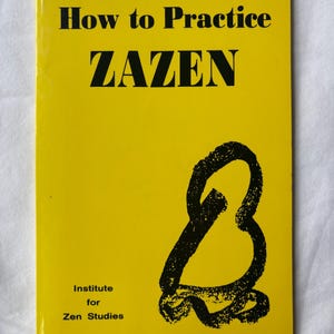 May include: A yellow book titled "How to Practice ZAZEN" with black text and a black abstract design. The book cover also includes the text "Institute for Zen Studies".