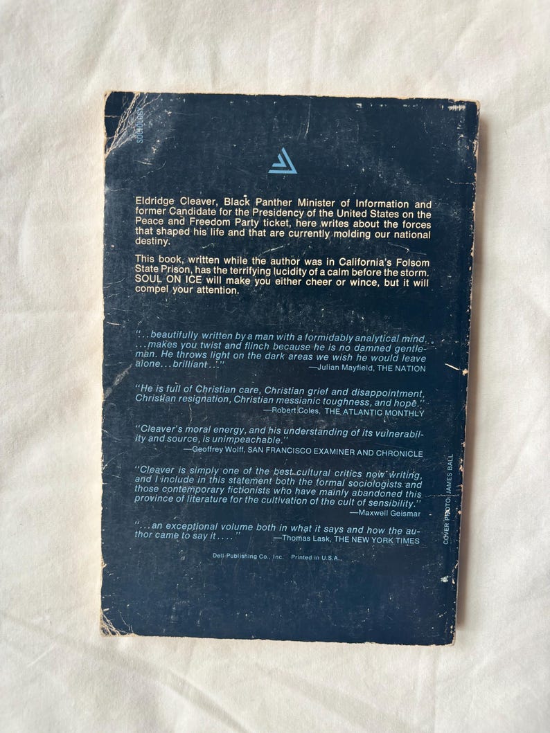 May include: Vintage paperback book titled "Soul on Ice" by Eldridge Cleaver. The cover is dark blue with white text and a triangular logo. The back cover features quotes and biographical information.