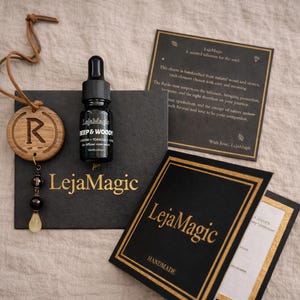 Puede incluir: Una botella de vidrio negro con un cuentagotas, un amuleto de madera con la letra "R" y varias tarjetas negras con letras doradas. La botella está etiquetada como "Deep & Woody". La marca "LejaMagic" es visible en las tarjetas.