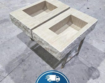 Peut inclure: Deux jardinières rectangulaires en pierre avec des ouvertures encastrées. Les jardinières sont de couleur beige clair et reposent sur des pieds en métal. Les jardinières sont conçues pour une utilisation en extérieur et ont une esthétique rustique et naturelle.