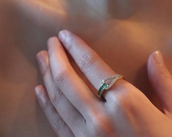 Anel dourado com zircônias cúbicas em formato de baguete, joia com pedra em tom esmeralda, design minimalista e aberto, peça moderna e marcante, presente perfeito para ela.