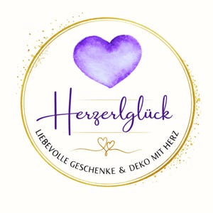 Puede incluir: Logotipo circular con borde dorado y un coraz&oacute;n morado en la parte superior. La palabra "Herzerlgl&uuml;ck" est&aacute; escrita en cursiva debajo del coraz&oacute;n. El texto "LIEBEVOLLE GESCHENKE & DEKO MIT HERZ" est&aacute; escrito alrededor del c&iacute;rculo.