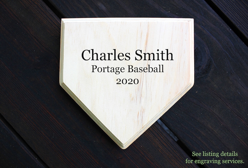 May include: A wooden home plate with the text "Charles Smith Portage Baseball 2020" engraved on it.