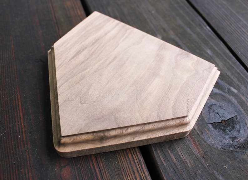 May include: A wooden home decor item shaped like a baseball diamond. The wood is a light brown color and has a natural grain pattern.
