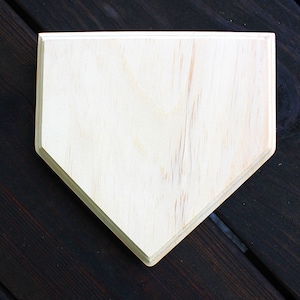 May include: A plain, unfinished wooden home plate, perfect for decorating or crafting.