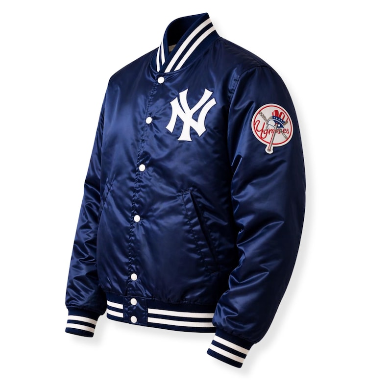 May include: Navy blue satin baseball jacket featuring the New York Yankees logo on the chest and a team patch on the sleeve. The jacket has white accents on the collar, cuffs, and hem, with a button-up front.