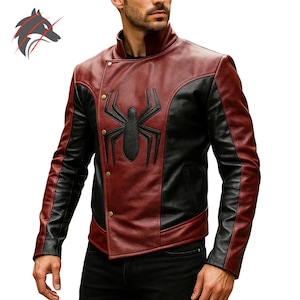 May include: A two-tone jacket in burgundy and black, featuring a large black spider emblem on the chest. The jacket has a stand-up collar and asymmetrical button closure. The sleeves are black, and the body is burgundy.