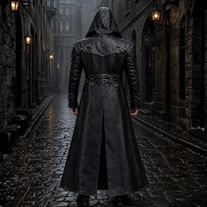 May include: A long, black leather hooded coat with a belted waist and decorative shoulder accents. The coat features a split back and is worn in a cobblestone alleyway.