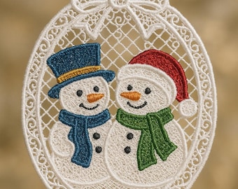 May include: White lace Christmas ornament featuring two snowmen. One snowman wears a blue top hat and scarf, the other a red Santa hat and green scarf. The ornament has a bow at the top and a blue string for hanging.