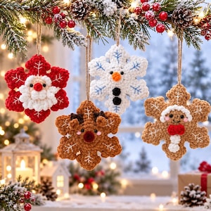 Può includere: Quattro decorazioni a forma di fiocco di neve all'uncinetto appese a un ramo di pino. Una è rossa e bianca con un volto di Babbo Natale, una bianca con un pupazzo di neve, una marrone con una renna e una marrone con un omino di pan di zenzero.