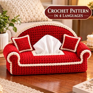 Puede incluir: Una funda de ganchillo roja para caja de pañuelos con forma de sofá en miniatura, ribete color crema y dos cojines cuadrados pequeños. El texto "CROCHET PATTERN IN 4 LANGUAGES" aparece en una insignia ovalada roja oscura.