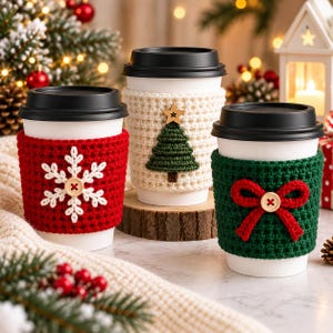 Peut inclure: Trois gobelets à café jetables blancs avec couvercles noirs, chacun doté d'une housse en crochet texturé. La housse rouge porte un flocon blanc, la crème un sapin vert et la verte un nœud rouge, toutes ornées de boutons en bois.