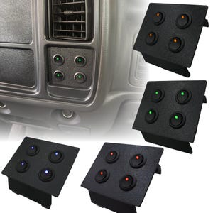 Puede incluir: Paneles de interruptores automotrices negros con cuatro botones redondos iluminados. Los botones se iluminan en verde, naranja, azul y rojo. Los paneles se muestran instalados en el salpicadero de un vehículo y como unidades individuales.