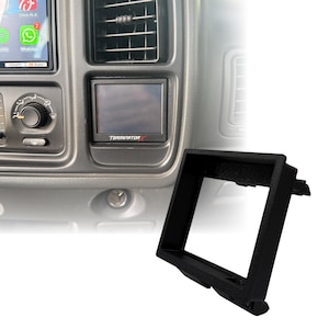 Puede incluir: Un bisel de plástico negro para el salpicadero de un vehículo, diseñado para alojar una pantalla digital. El bisel es rectangular con una superficie texturizada y se muestra junto a un salpicadero con una pantalla que muestra "TERMINATOR X".
