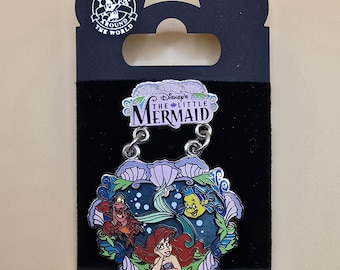 Pin colgante oficial vintage de Disney que muestra a Ariel, Flouder y Sebastián y dice "La Sirenita".