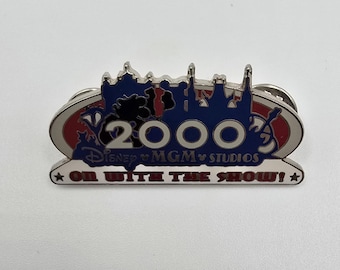 Pin oficial vintage de Disney para los estudios MGM que dice "2000" y "On With the Show".