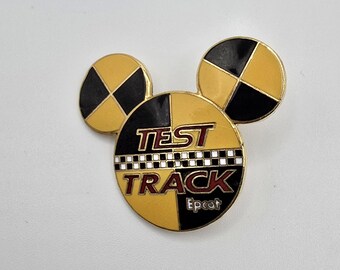 Pin oficial vintage de Disney para la pista de pruebas de Epcot. Tiene un diseño amarillo y negro dentro de la cabeza y las orejas de Mickey Mouse.