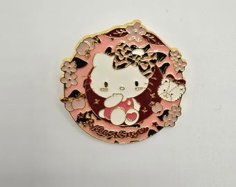 Pin de Hello Kitty vestida de rosa con un lazo de leopardo y flores a su alrededor.