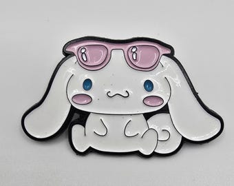 Pin de Cinnamoroll con ojos azules y mejillas rosadas con gafas de sol rosas en la cabeza.
