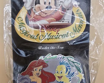 Pin musical oficial vintage de Disney que muestra a Ariel y Flounder de La Sirenita y dice "Bajo el mar".