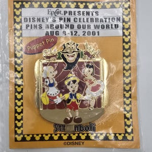 May include: A Disney's Pin Celebration pin featuring Pinocchio and other characters from the movie. The pin is in a plastic sleeve and has the text "Epcot PRESENTS DISNEY'S PIN CELEBRATION PINS AROUND OUR WORLD AUG 9-12, 2001".