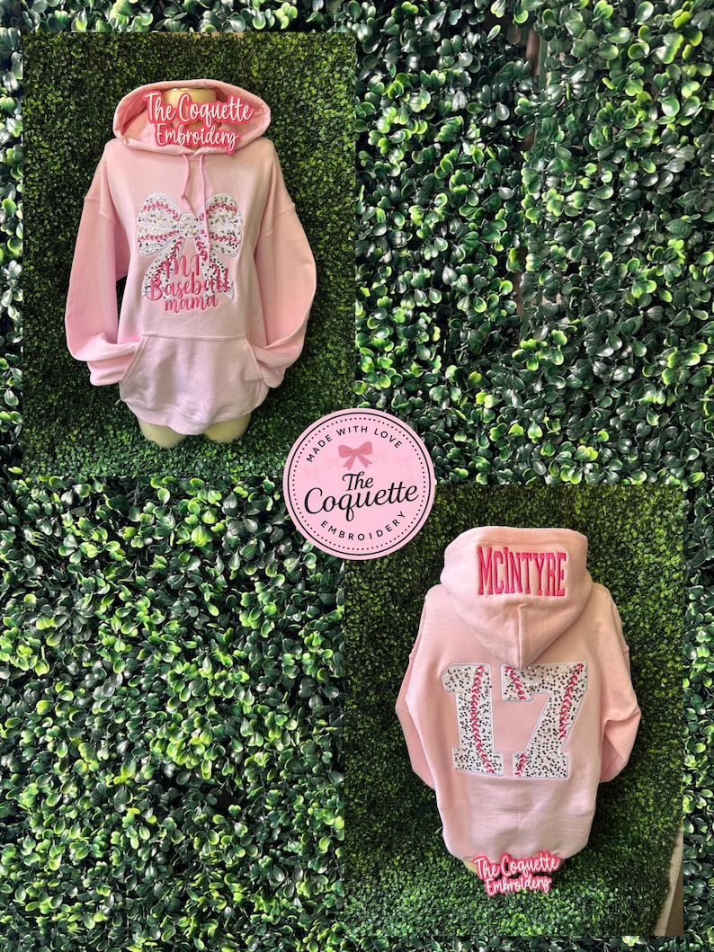 May include: Pink hooded sweatshirt with the text "#1 Baseball Mama" and a bow design on the front. The hood has the text "The Coquette Embroidery". The back of the sweatshirt has the name "McIntyre" and the number "17".