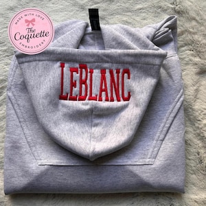 May include: A set of three ceramic mugs with a speckled, matte finish. The mugs are in shades of cream, light gray, and dark gray. Each mug has a simple, minimalist design, perfect for coffee or tea.