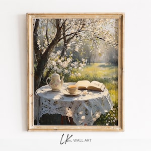 May include: A framed painting shows a tranquil outdoor scene. A small table with a white lace tablecloth has a teapot, teacup, and an open book. The background features a blossoming tree and a sunlit meadow. The artwork is signed "LK WALL ART".