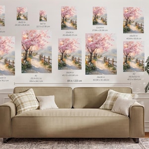 May include: Watercolor painting of a path lined with a wooden fence and cherry blossom trees. Various sizes are displayed, including 12x36 inches, 8x10 inches, and 16.5x23.5 inches. The artwork is displayed above a sofa.