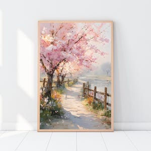 May include: A framed watercolor painting of a path lined with cherry blossom trees. The trees have pink and white blossoms. A wooden fence runs along the path, and a body of water is visible in the background. The painting is in a light wood frame.