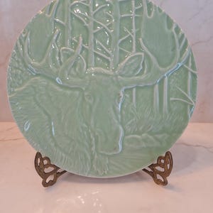 May include: A set of three ceramic mugs with a speckled, matte finish. The mugs are in shades of cream, light gray, and dark gray. Each mug has a simple, minimalist design and a rounded handle.