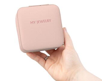 Estuche compacto de viaje para joyas, color rosa, con compartimentos para anillos y pendientes, y bolsa con cremallera.