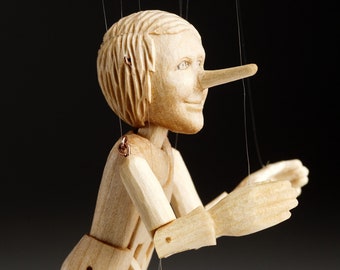 La marionetta di Pinocchio più piccola del mondo, scolpita con precisione a mano in legno di tiglio